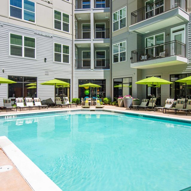 Live 8 West - Modern swimming pool with lounge chairs and large umbrella