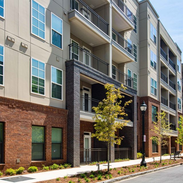 Live 8 West - Apartment exterior view with trees and paved way
